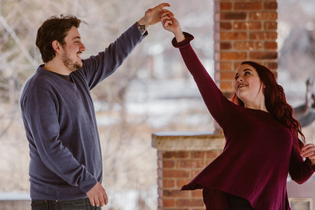 Man spinning his fiancé, both smiling
