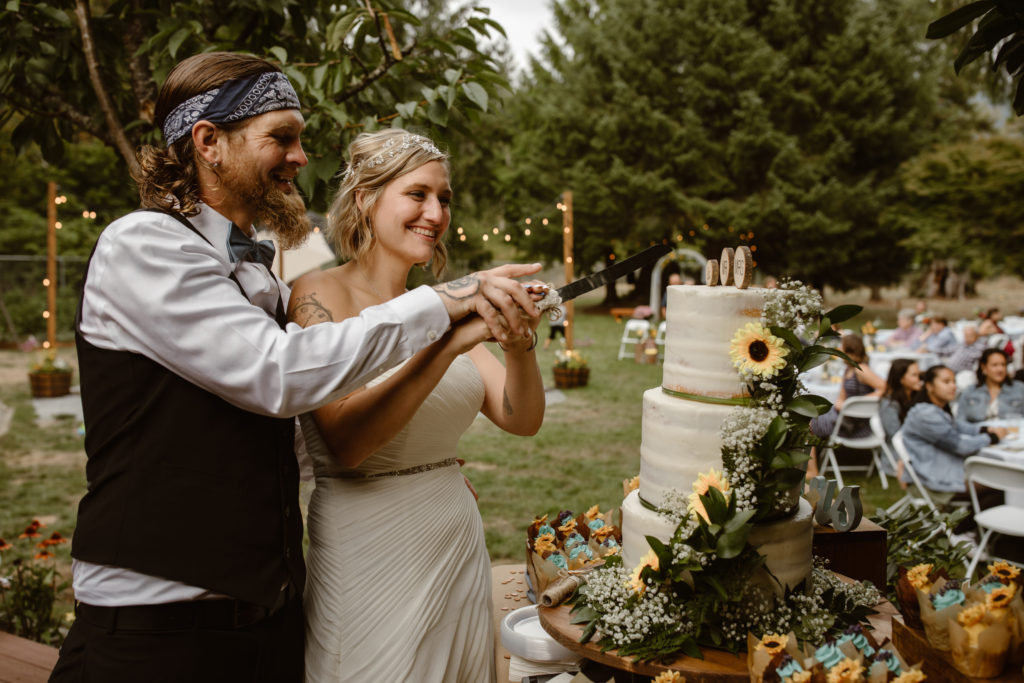 Newly married couple cutting their cake together.
