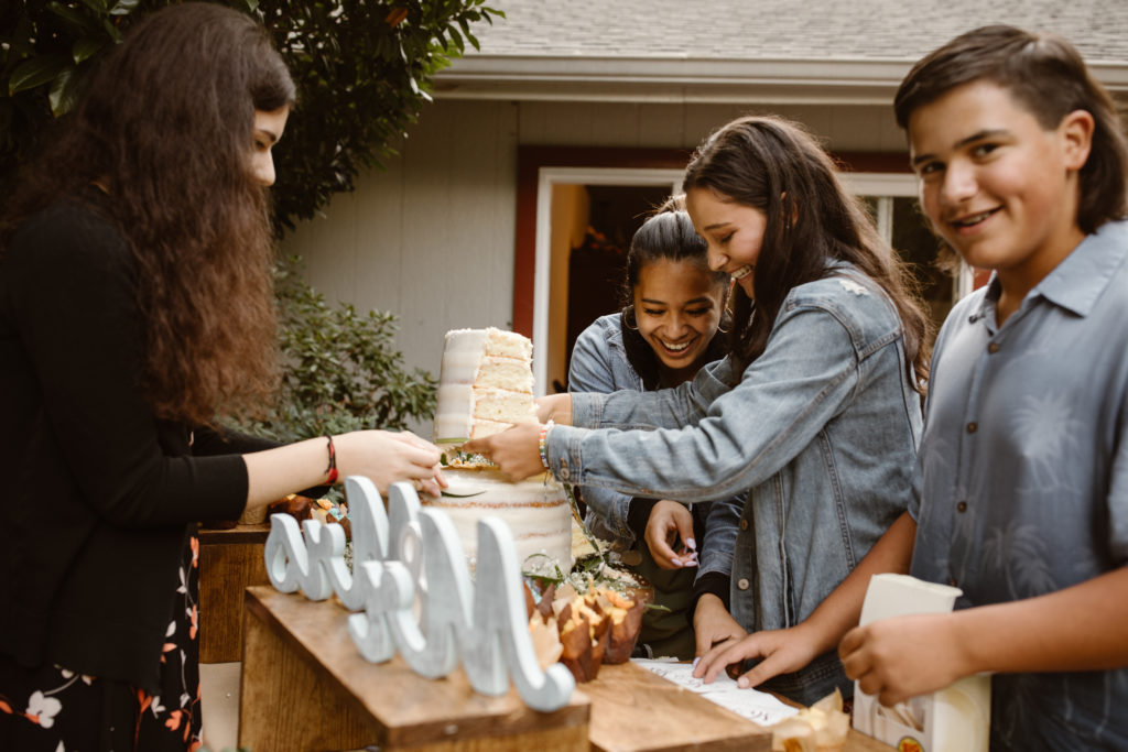 Kids helping cut the wedding cake