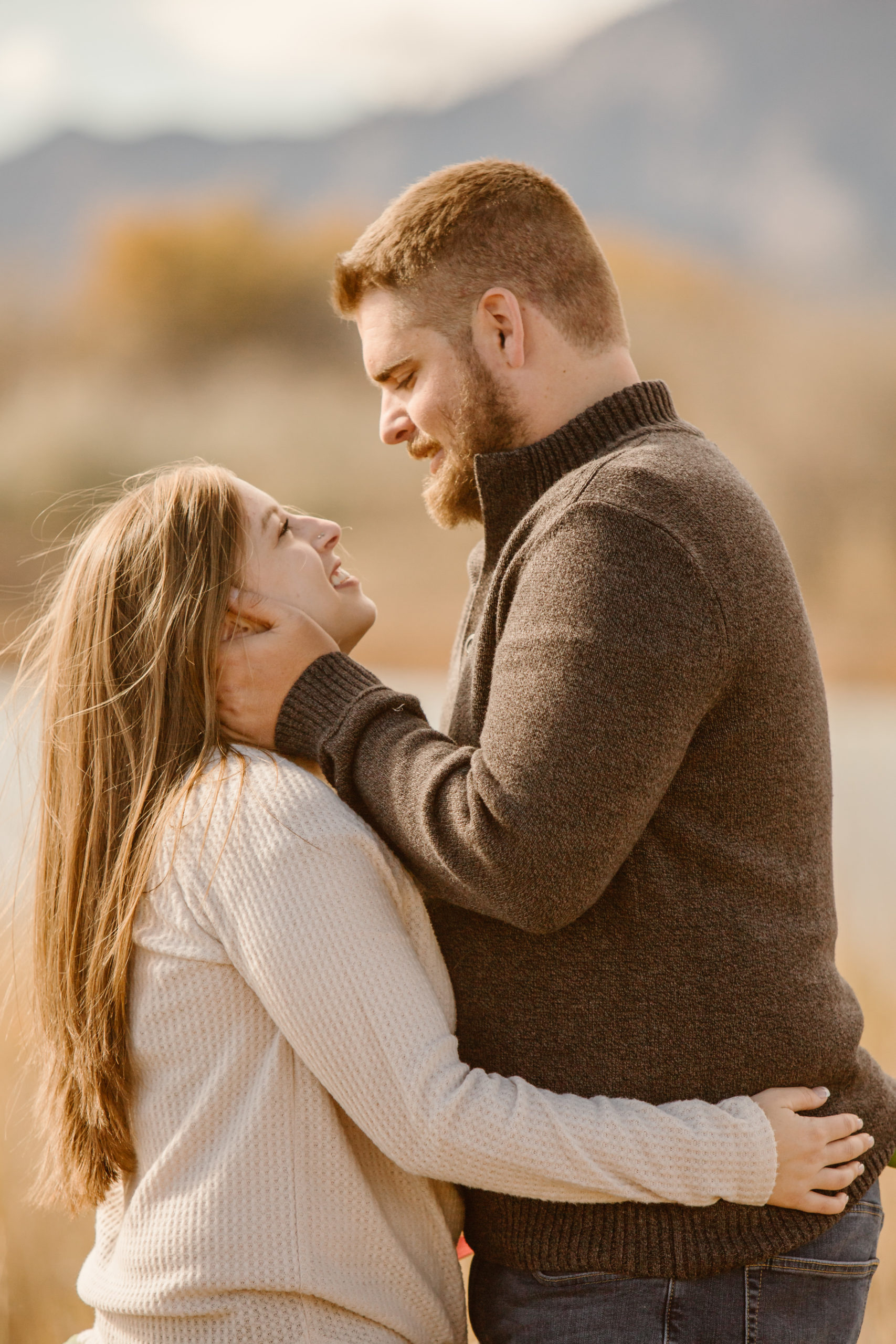 Couple facing each other, mans hands holding his fiancé's head