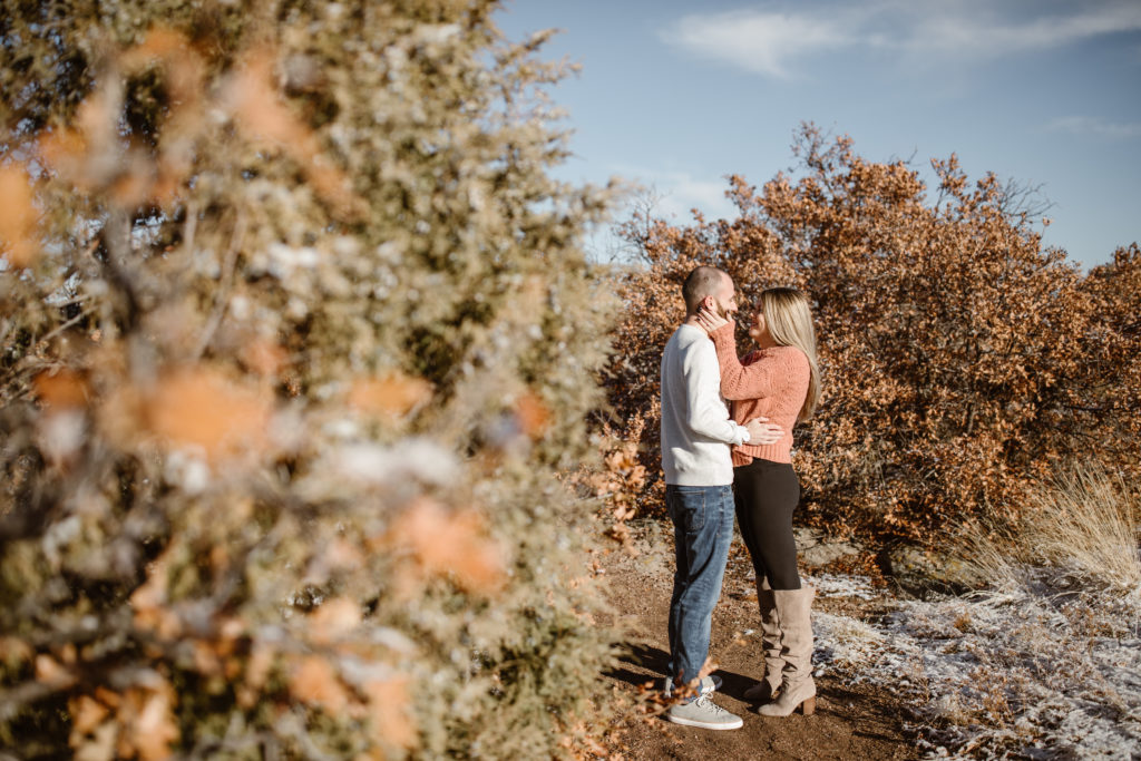 Couple smiling looking at each other, woman's hands on his face