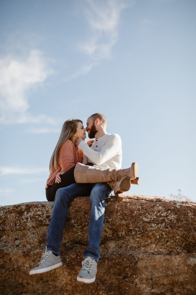 Couple about to kiss with the bright blue sky behind them