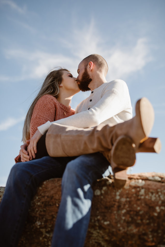 Couple kissing with the bright blue sky behind them