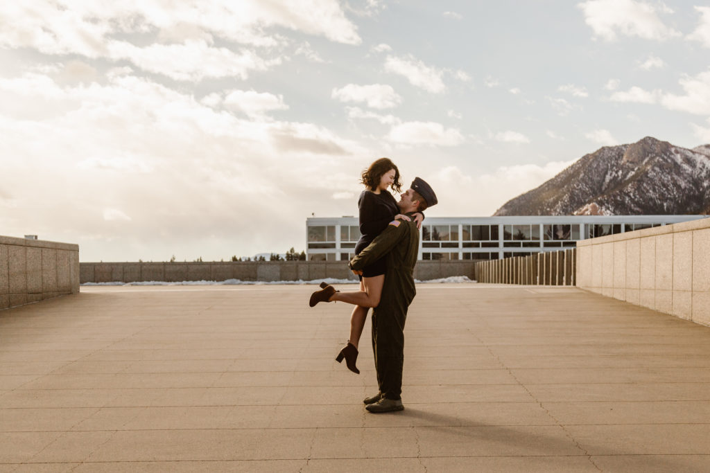 Man in Air Force uniform outside the United States Air Force Academy Cadet Chapel picking up his fiancé