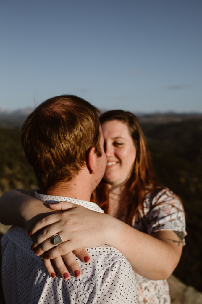 Woman's arms around fiancé highlighting her engagement ring