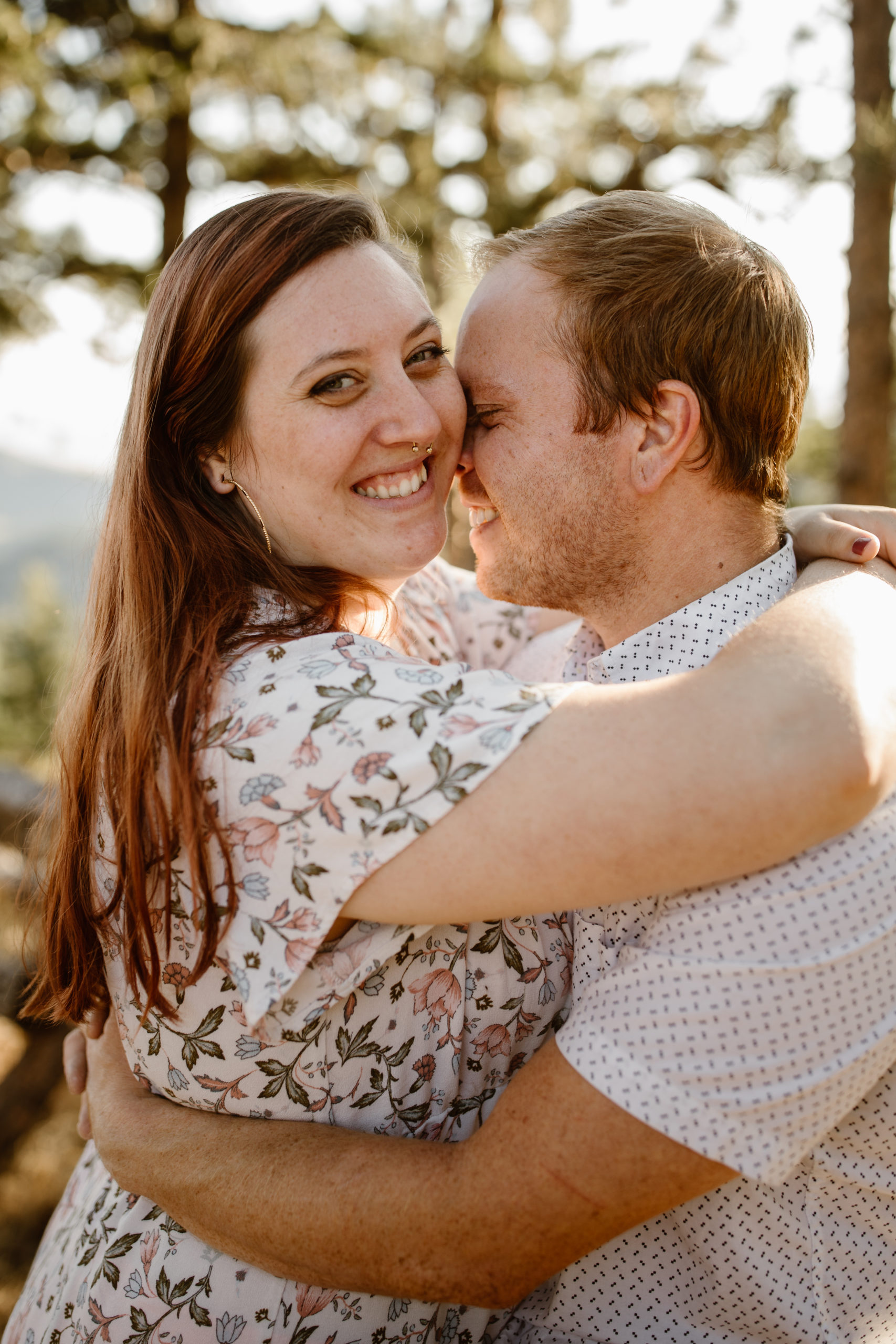 Woman looking at camera while her fiancé hugs her