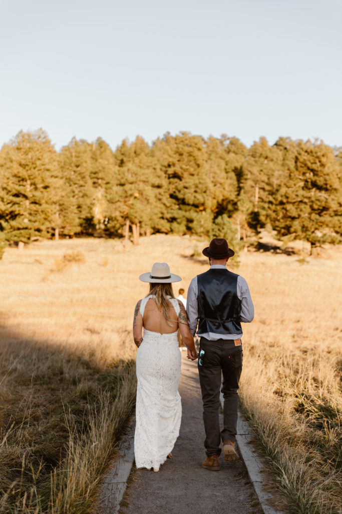 Bride and groom holding hands walking away