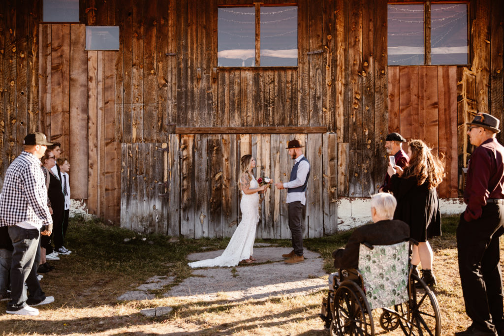 Bride and groom reading vows with family surrounding them