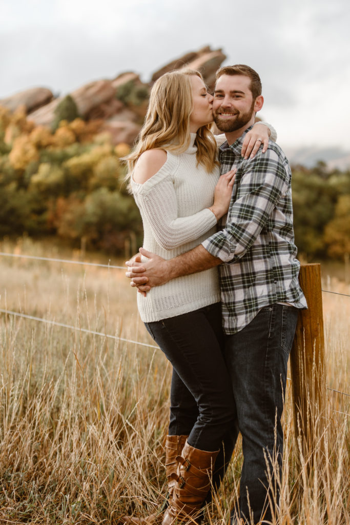 Couple with arms around each other. Woman kissing man on the cheek