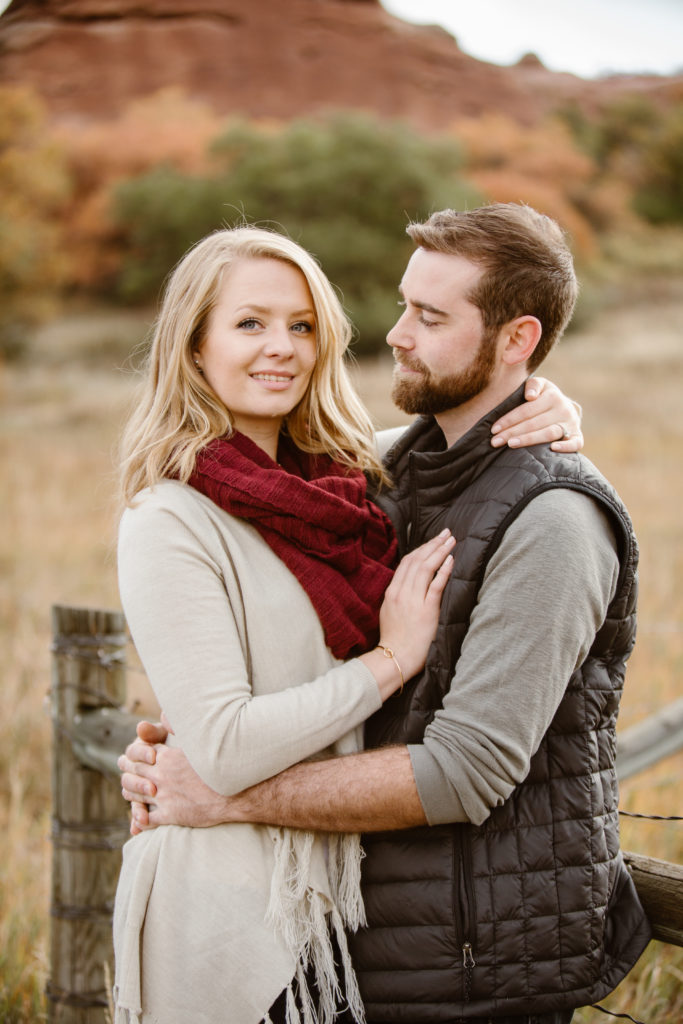 Couple arms wrapped around each other. Woman looking at the camera, man looking at the woman