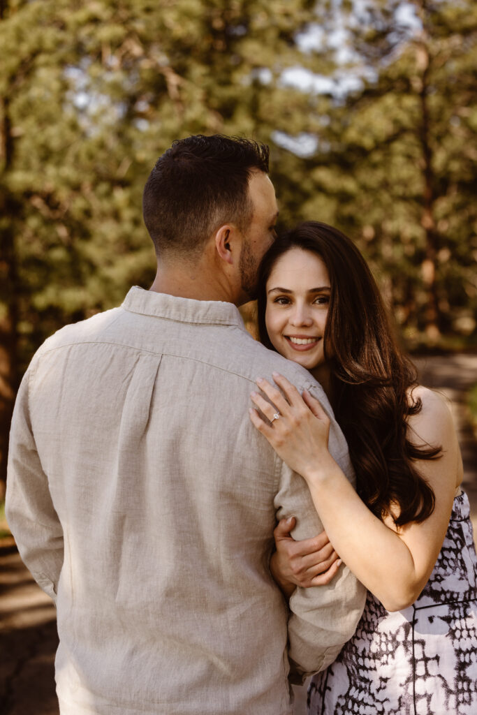 Woman holding her fiancé's arm looking over his shoulder