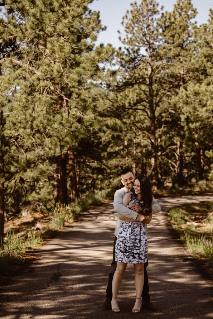 Man holding his fiancé in a bear hug with both of them smiling