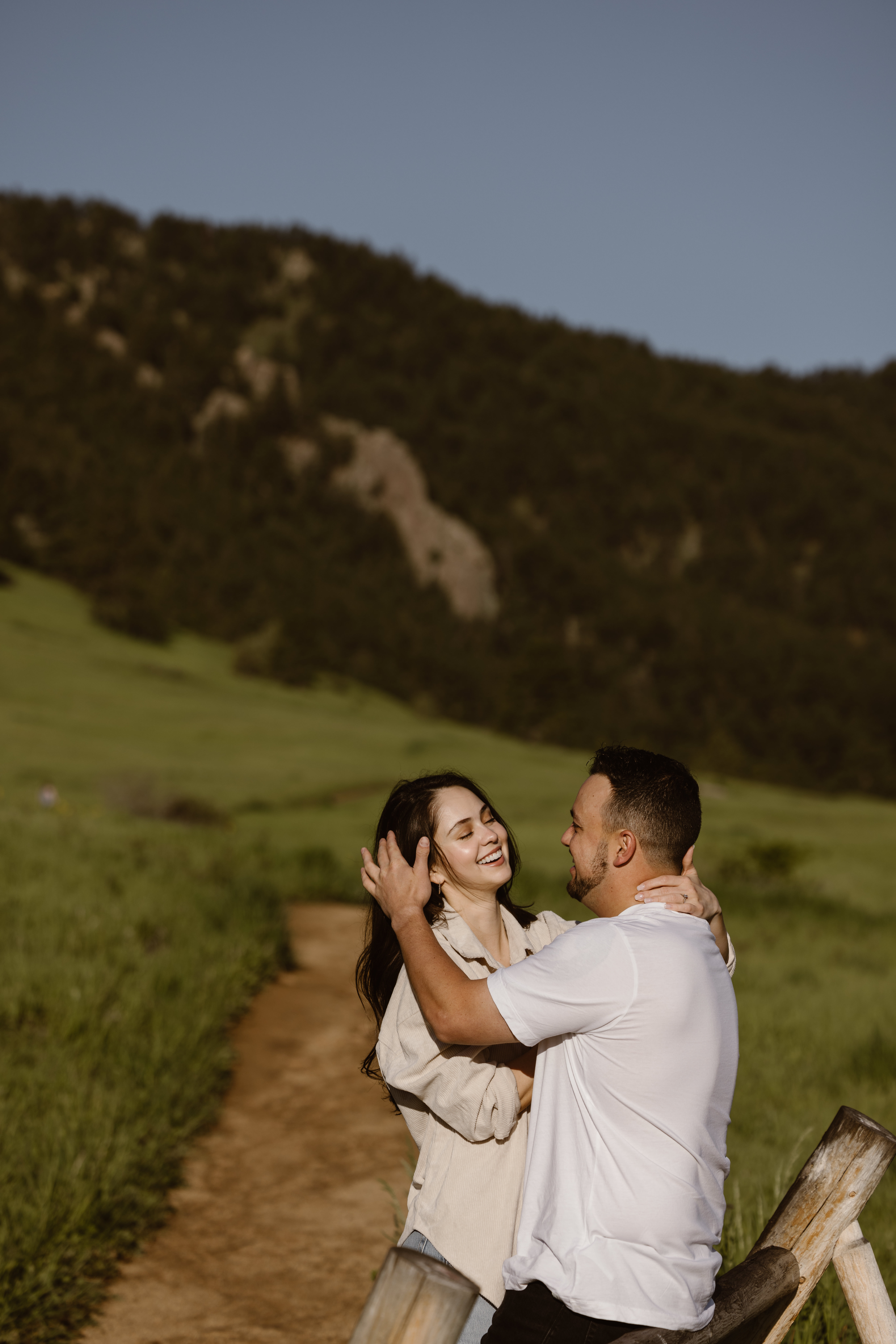Man tucking hair behind his fiancé's ear