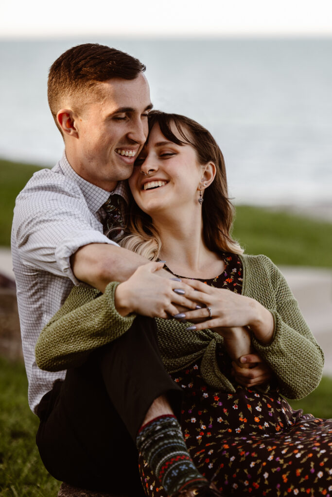 Man behind his fiancé with his arms wrapped around her and they are laughing