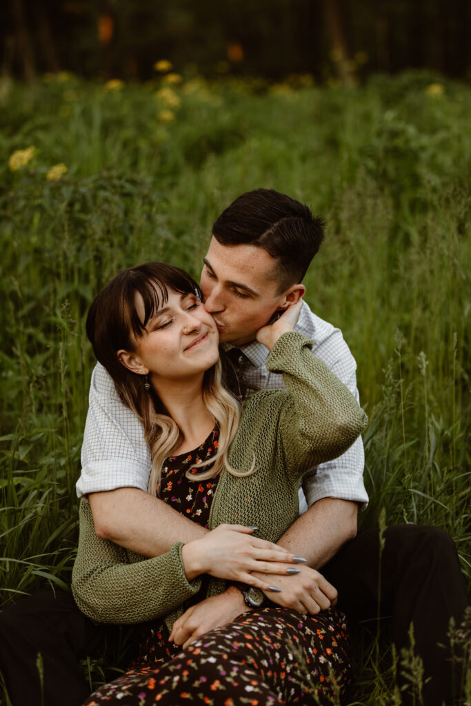 Man behind his fiancé with his arms wrapped around her and they are laughing