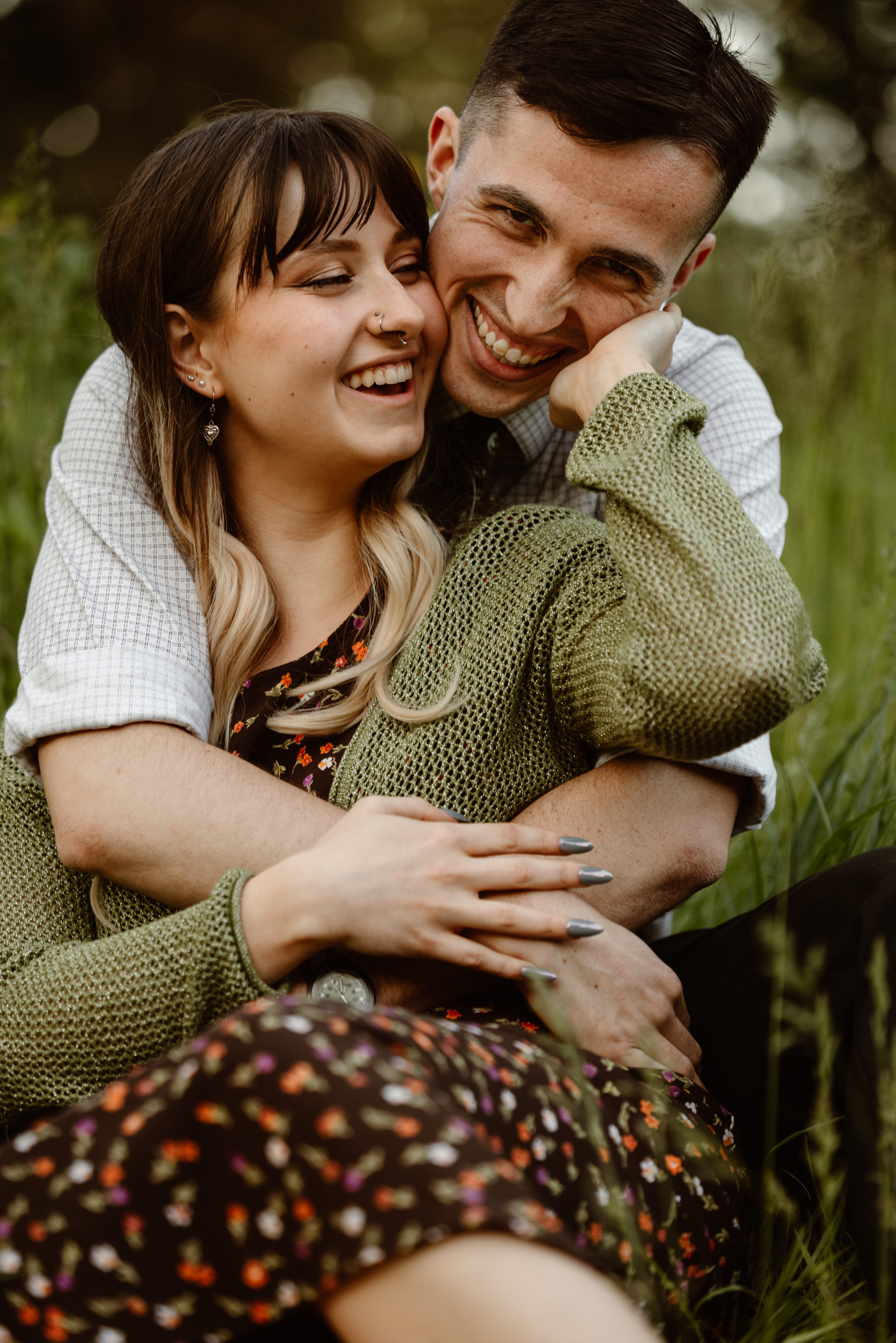 Man behind his fiancé with his arms wrapped around her and they are laughing