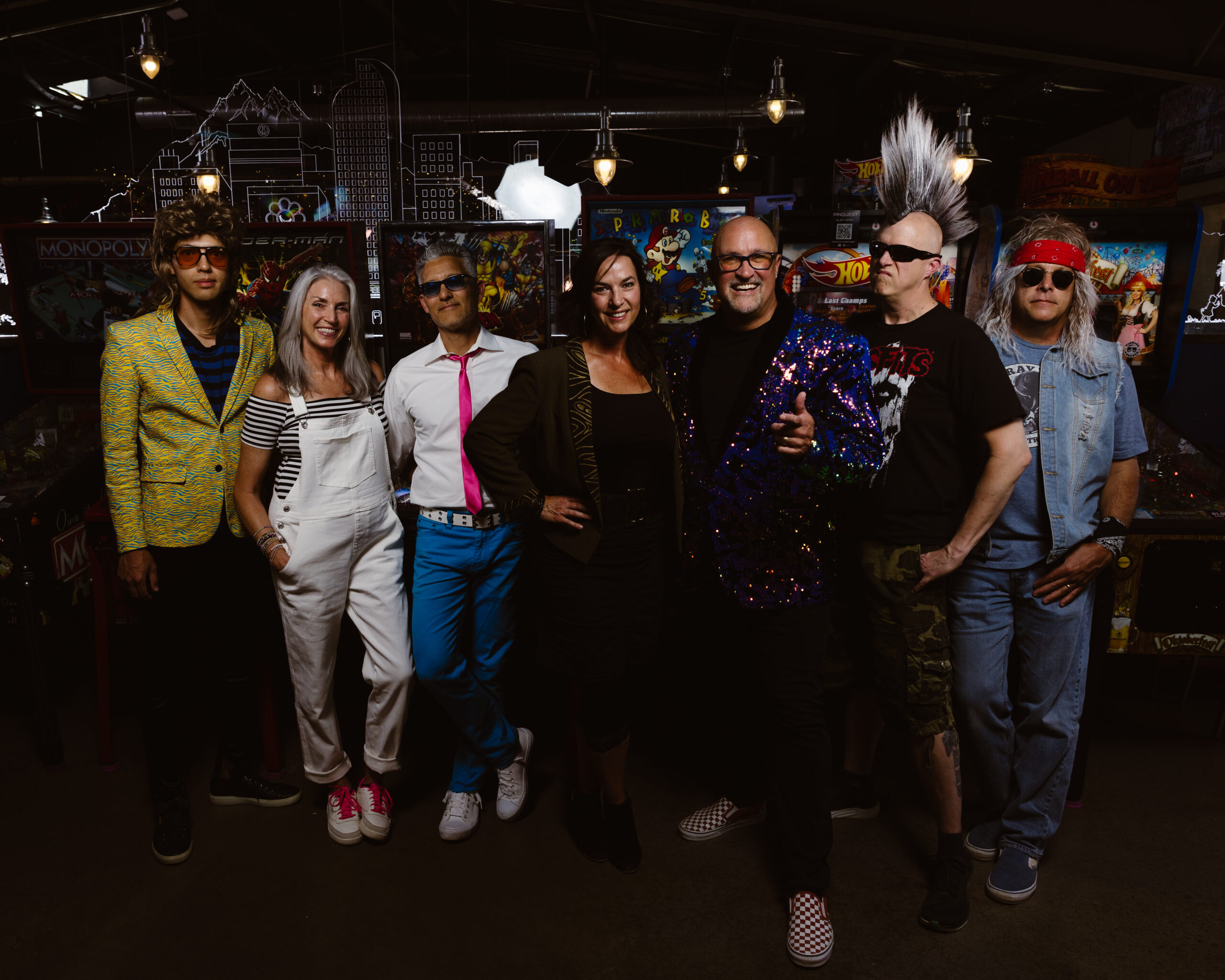 Full band portrait in front of old arcade games