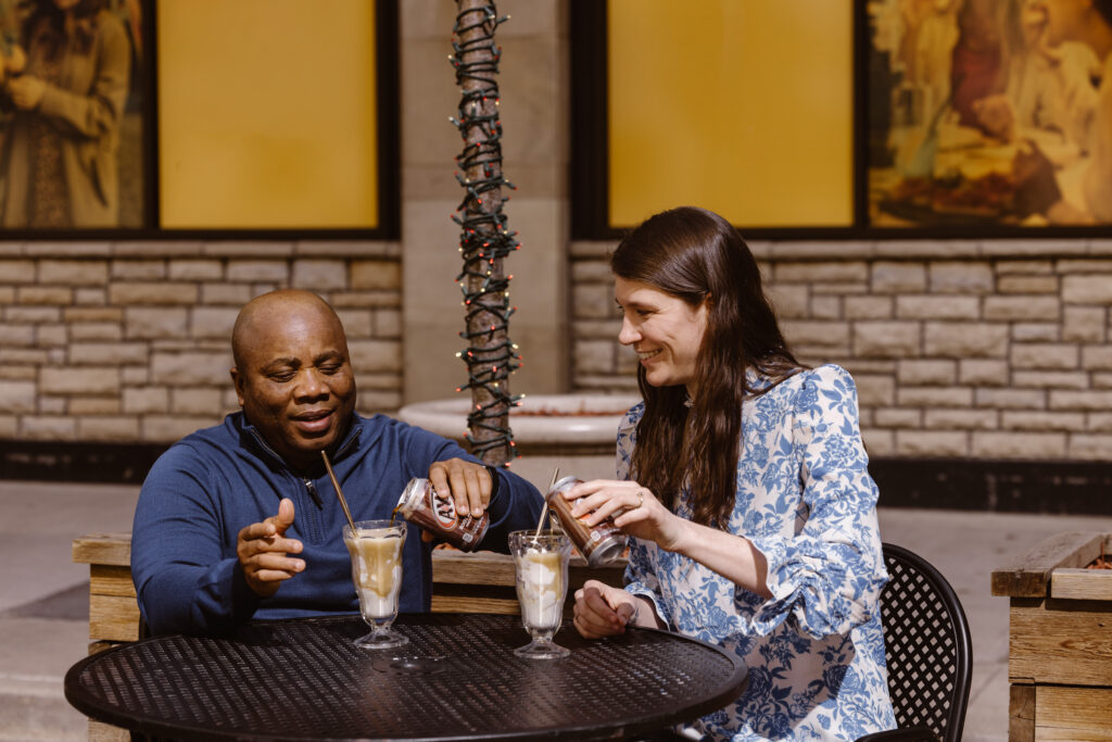 Couple making root beer floats at an outside table