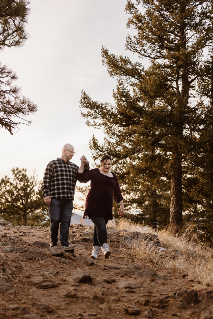 Couple walking down a rocky path hand in hand