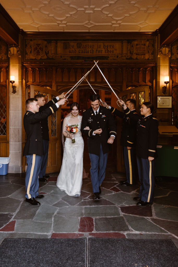 Bride and groom walking under a sword arch after wedding ceremony