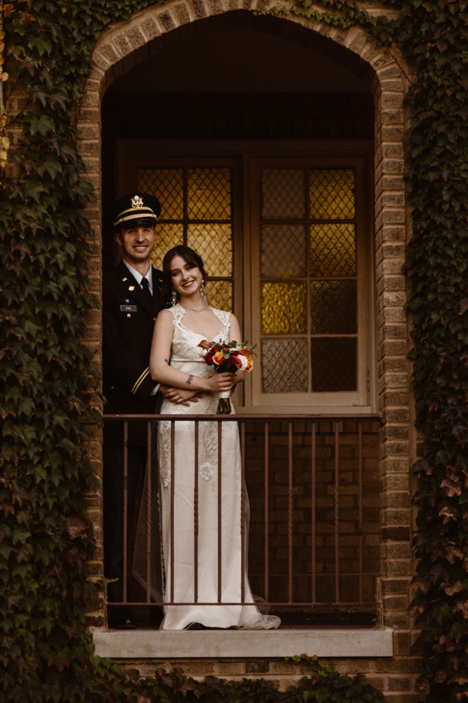 Bride and groom portrait, framed in a brick arch