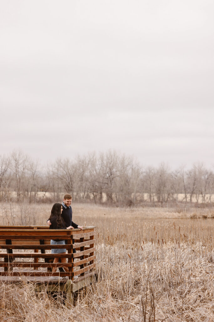 Couple on a bridge looking out at the lake