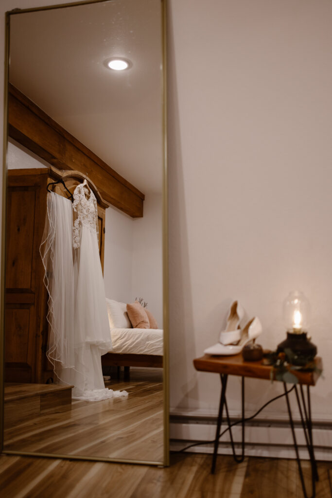 Wedding dress hanging inside a cozy Colorado Airbnb where the couple got ready before their elopement ceremony.