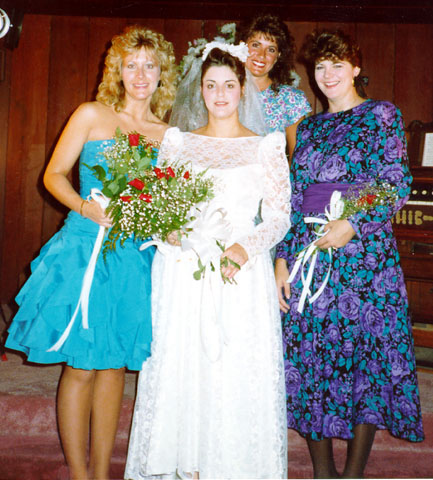 Bride standing with bridesmaids during her vintage Las Vegas elopement ceremony inside a small chapel.