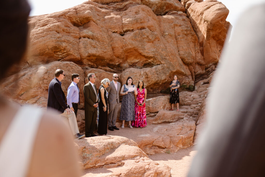 Small group gathered on red rock formations during an intimate Colorado elopement ceremony at Garden of the Gods.