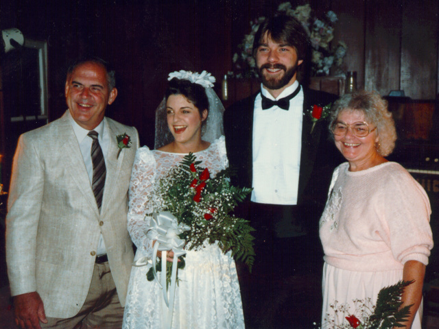 Bride and groom smiling with family members during their vintage Las Vegas elopement inside a small chapel.