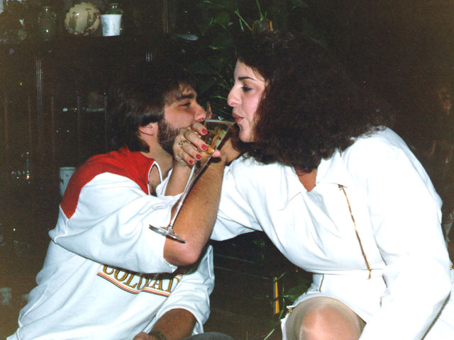 Newly married couple sharing a champagne toast during their vintage Las Vegas elopement celebration in the 1960s.
